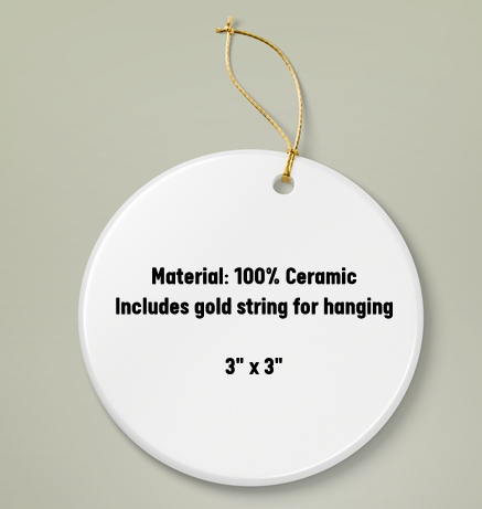 White ceramic round ornament with gold string for hanging on a beige background