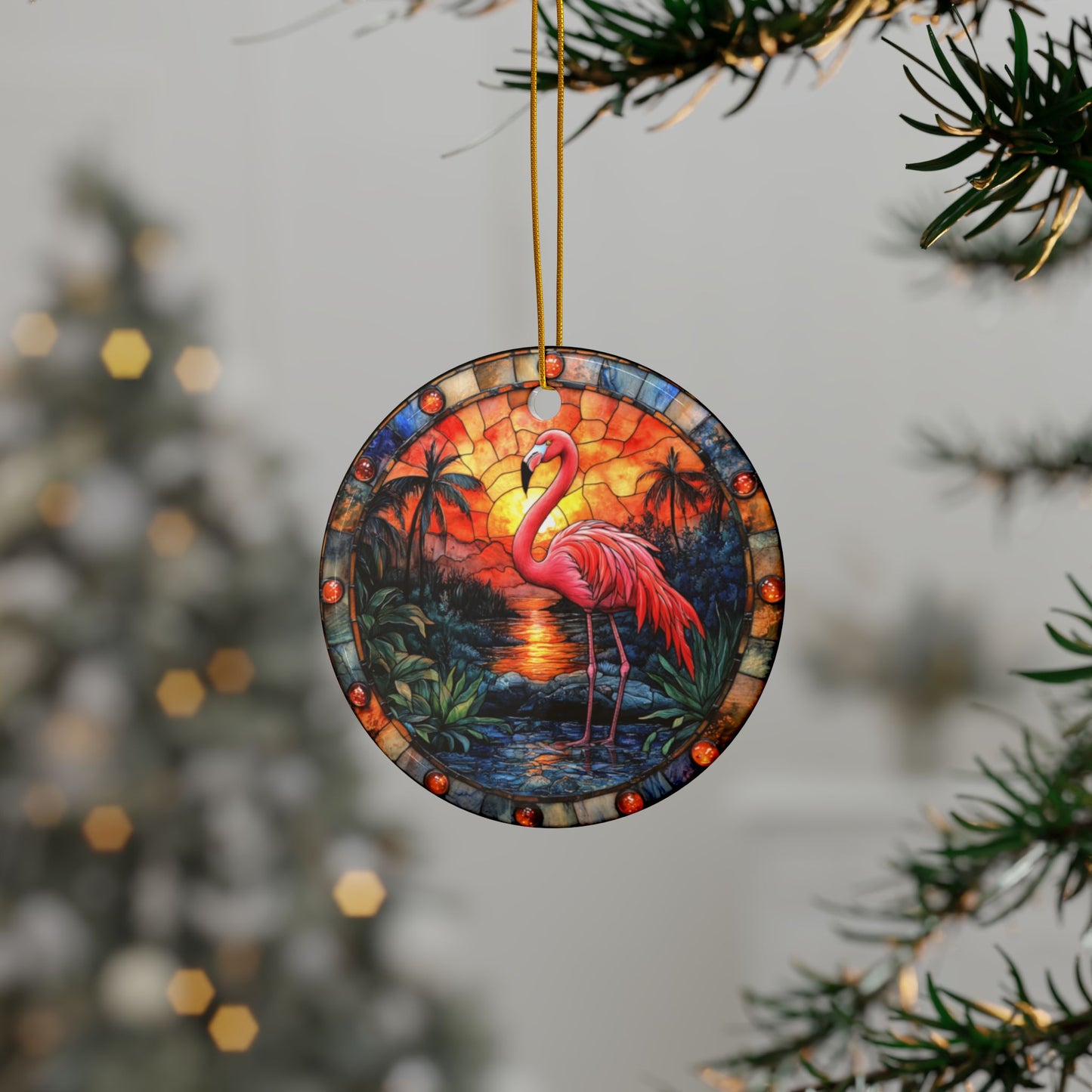 Decorative ornament with a flamingo design hanging on a tree branch.